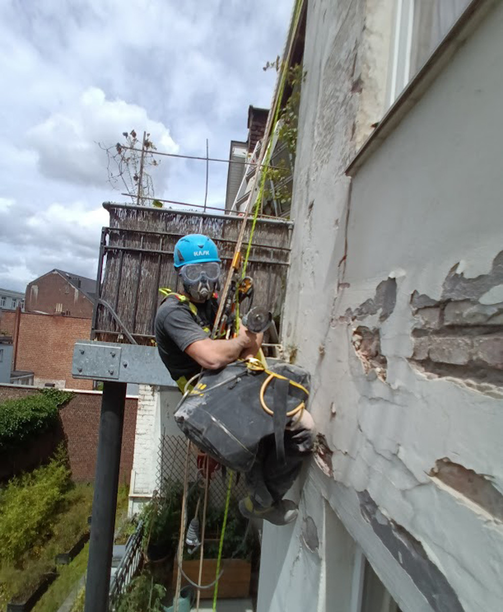 Travaux de rénovation de façade en accès difficile par un technicien cordiste spécialisé de chez Vertikal Pro.